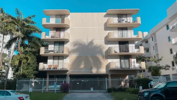 a front view of residential houses with outdoor space and parking