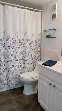a bathroom with a toilet and a shower
