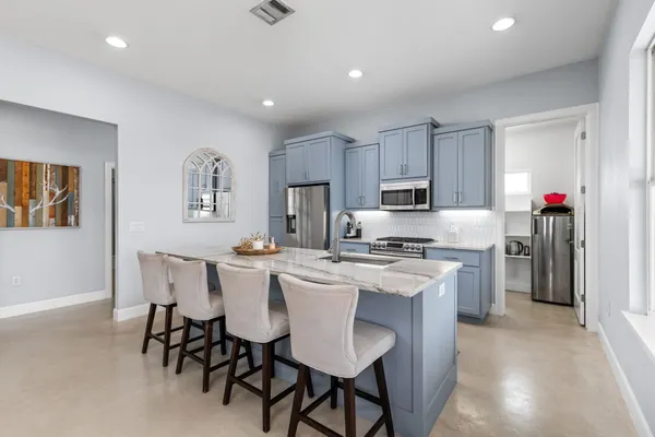 a kitchen with refrigerator cabinets dining table and chairs