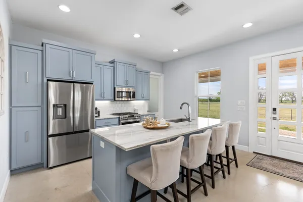 a kitchen with stainless steel appliances a sink stove and cabinets