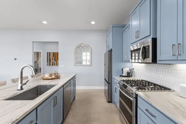 a kitchen with sink stove and cabinets