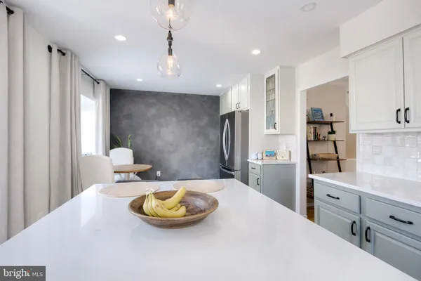 a kitchen with stainless steel appliances kitchen island granite countertop a sink refrigerator and cabinets