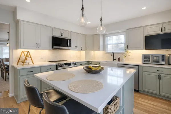 a kitchen with a sink a stove a microwave and cabinets