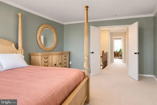 a bedroom with a bed a mirror with desk and chair