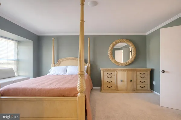 a bedroom with a bed a mirror and a window