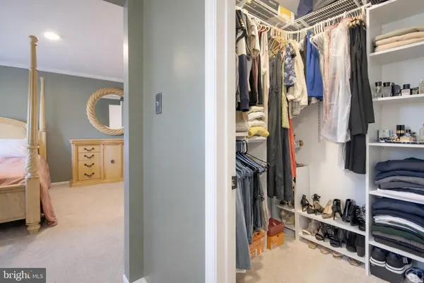 a view of walk in closet with clothes and shoes