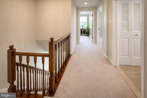a view of a hallway with wooden floor and windows