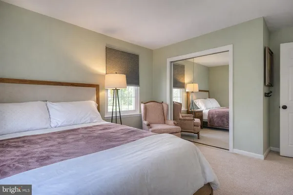 a bedroom with a bed and a large mirror