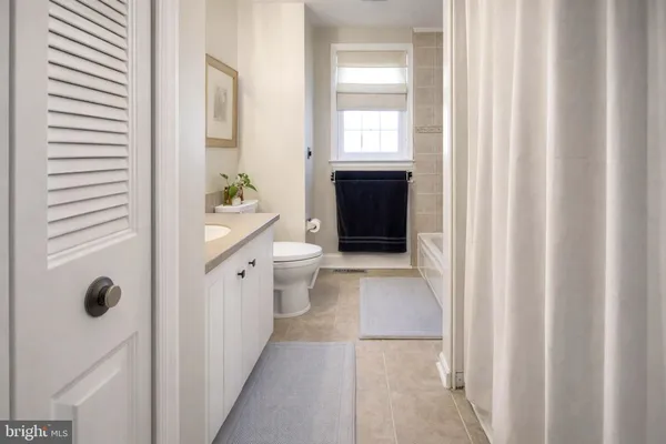 a bathroom with a sink a toilet and shower curtain