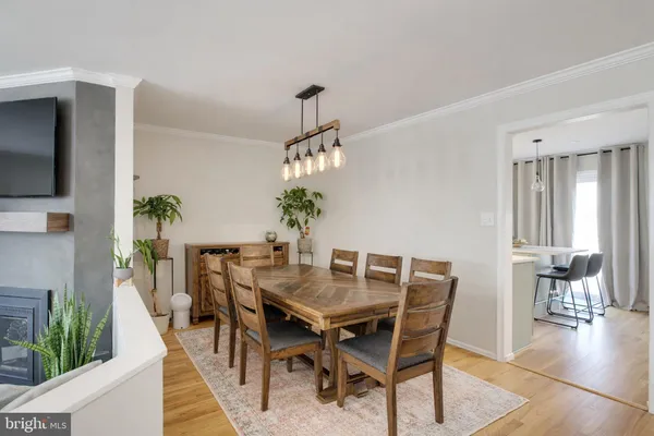 a dining room with furniture potted plants and wooden floor
