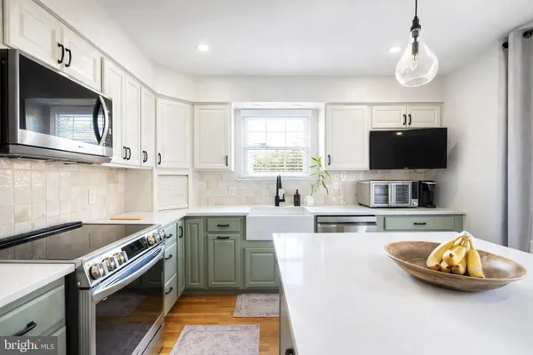 a kitchen with stainless steel appliances a stove a sink and a microwave