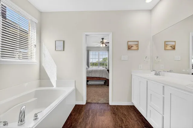 a bathroom with a tub sink and mirror