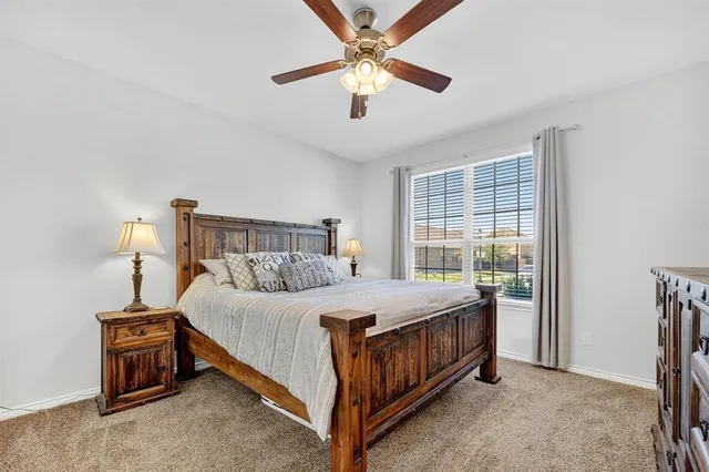 a bedroom with a bed chandelier and a window