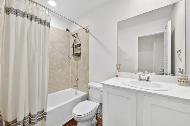 a bathroom with a sink a toilet a mirror a bathtub and shower