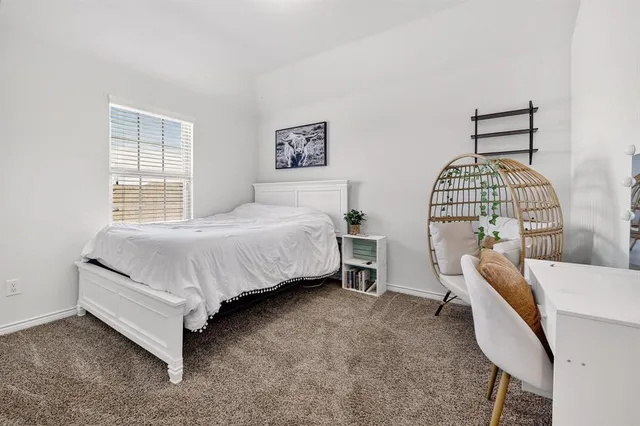 a bedroom with a bed chair and window