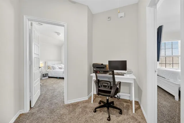 a view of a workspace with furniture and a window