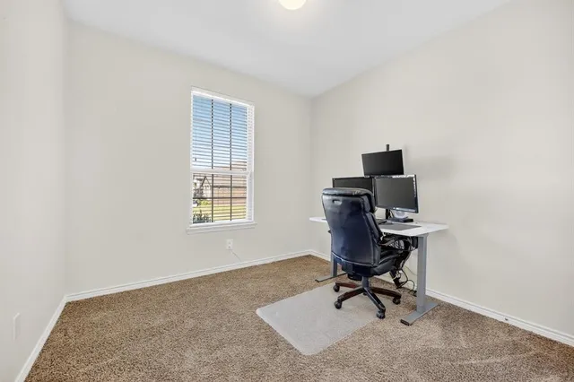 a view of a workspace with furniture and a window