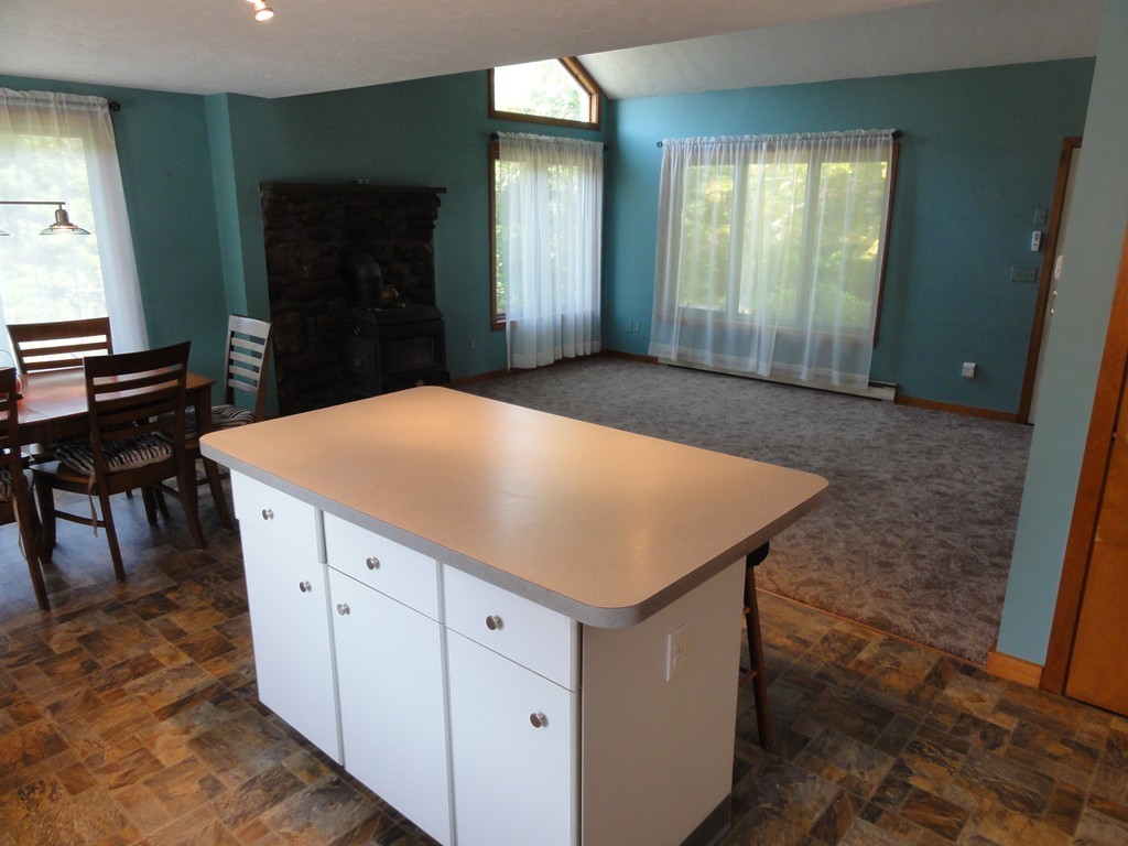 132 Groton Road Shirley, MA 01464 - Photo 7 of 29 a kitchen with a wooden floor and white cabinets