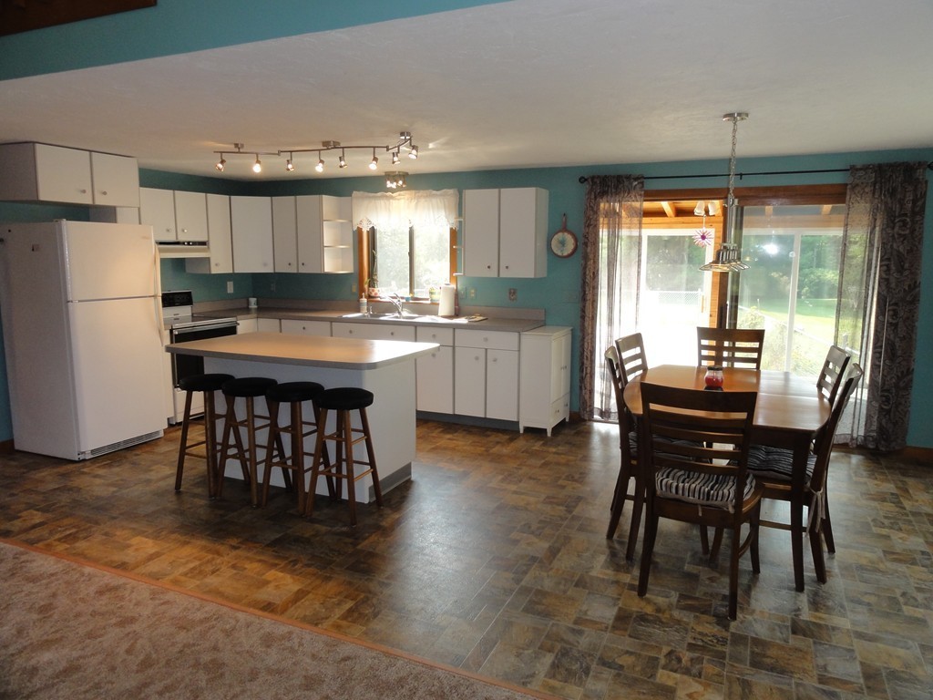 132 Groton Road Shirley, MA 01464 - Photo 8 of 29 a kitchen with a table chairs refrigerator and cabinets