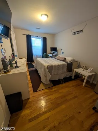 a spacious bedroom with a bed and a dresser