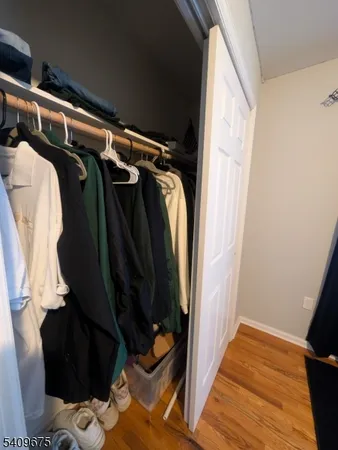 a view of walk in closet with clothes and shoes