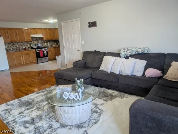 a living room with furniture and a dining table with kitchen view