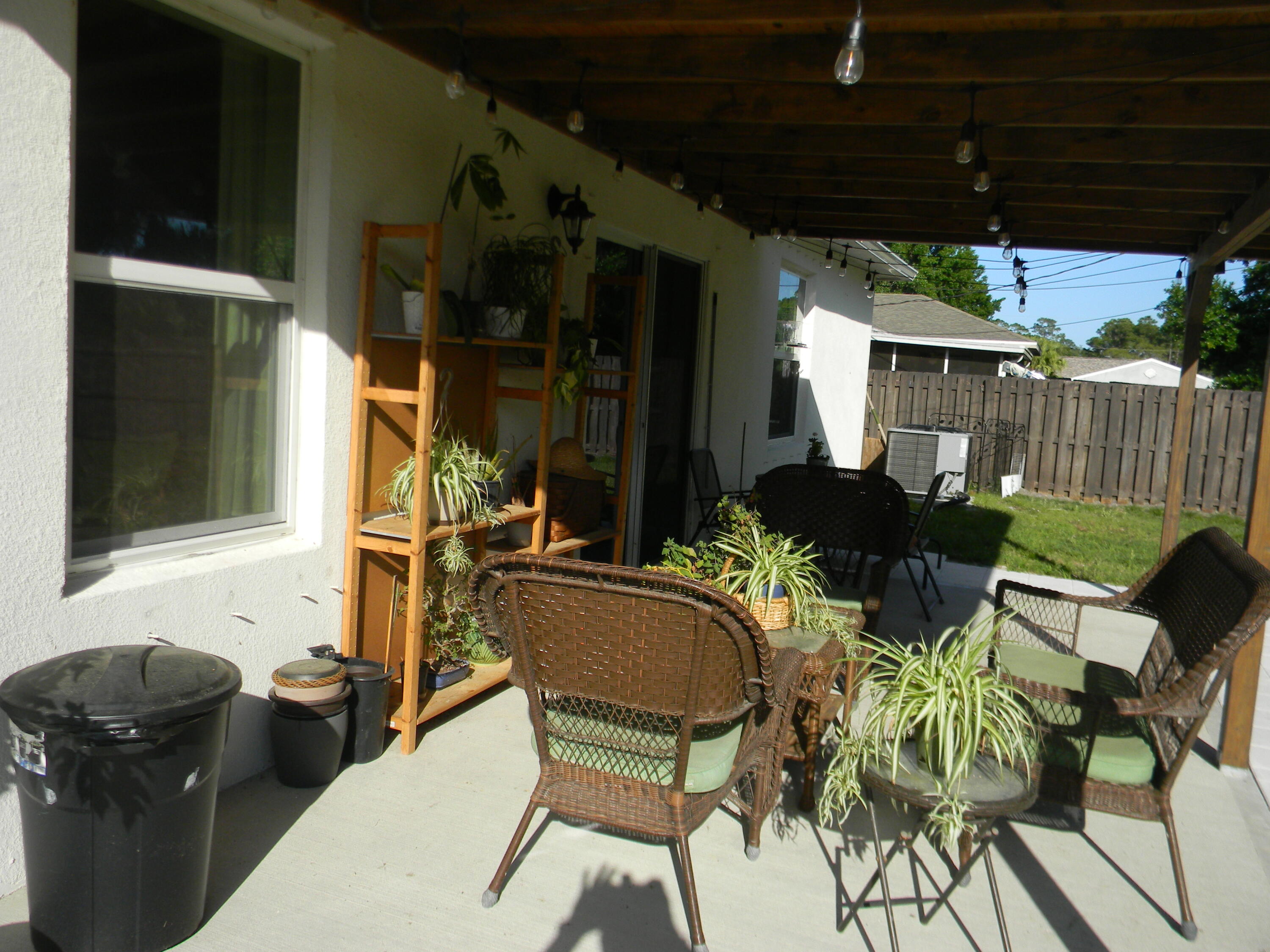 1588 Ranger Road Southeast Palm Bay, FL 32909 - Photo 39 of 52 a view of a patio with table and chairs potted plants with wooden fence