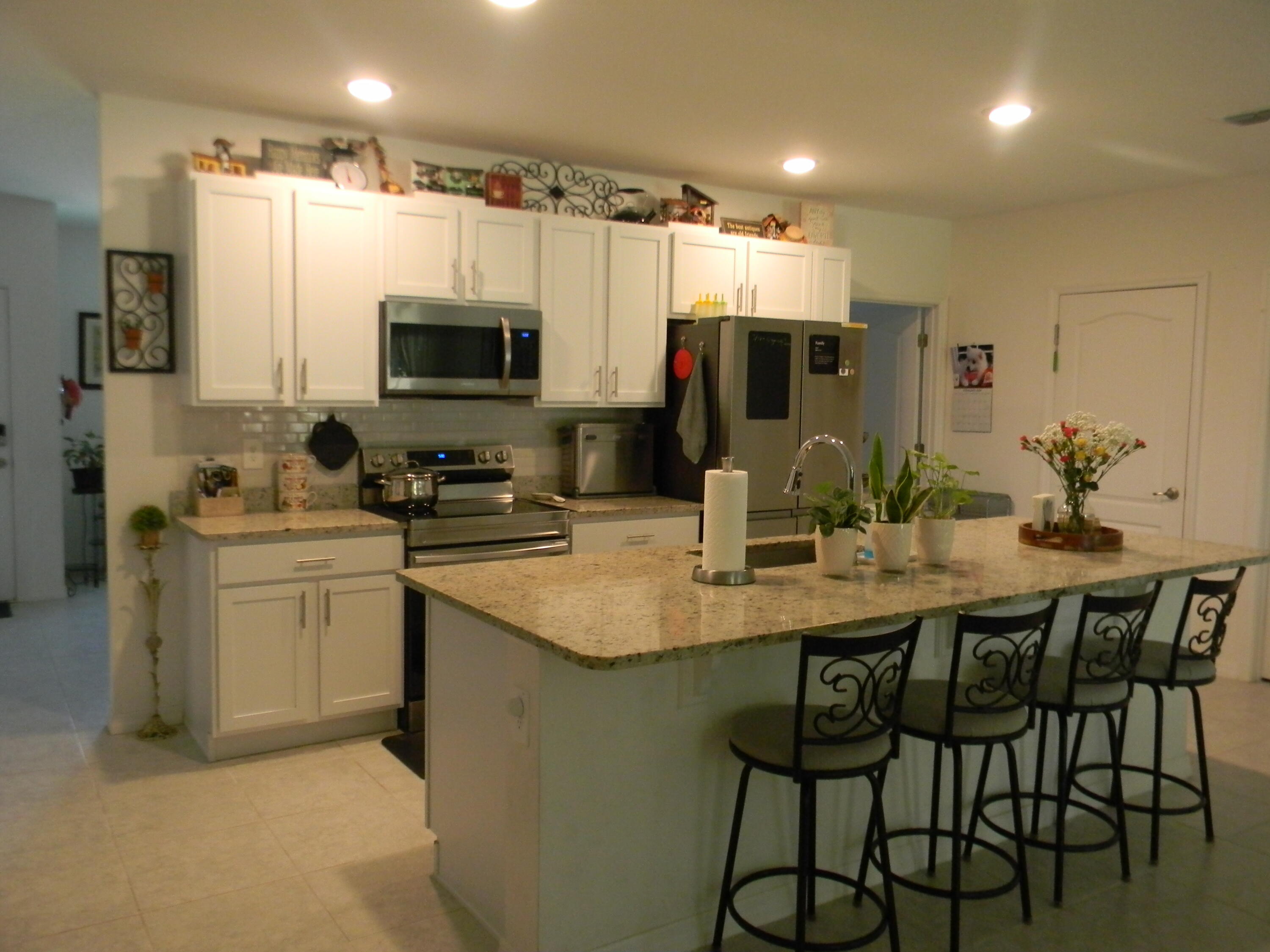 1588 Ranger Road Southeast Palm Bay, FL 32909 - Photo 9 of 52 a kitchen with stainless steel appliances kitchen island granite countertop a sink and cabinets