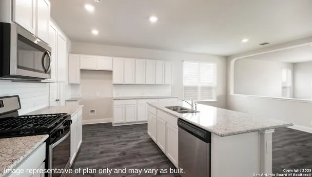 a kitchen with stainless steel appliances granite countertop a sink stove and cabinets