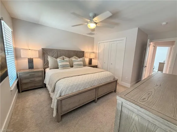 a bedroom with a bed a couch and a chandelier