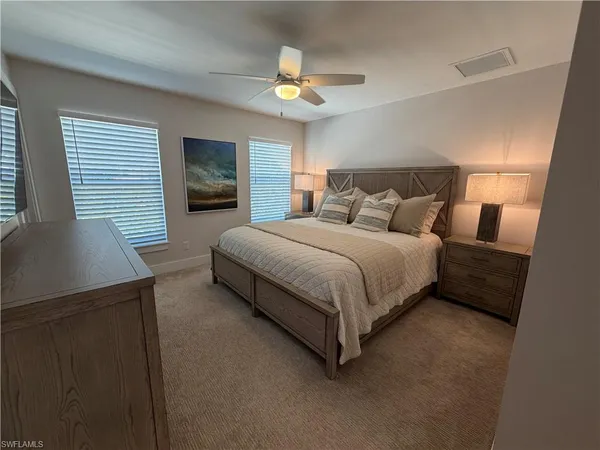 a bedroom with a bed lamps and window