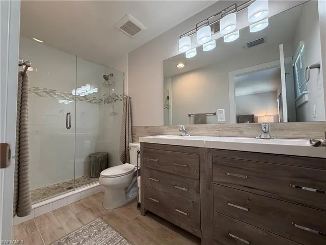 a bathroom with a double vanity sink mirror and toilet