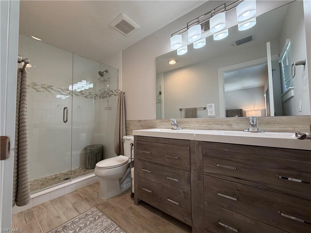 1727 Danford Street Naples, FL 34112 - Photo 14 of 15 a bathroom with a double vanity sink mirror and toilet