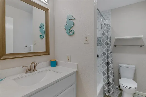 a bathroom with a granite countertop sink a toilet and a mirror