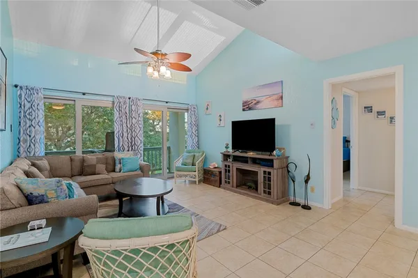a living room with furniture a flat screen tv and a large window