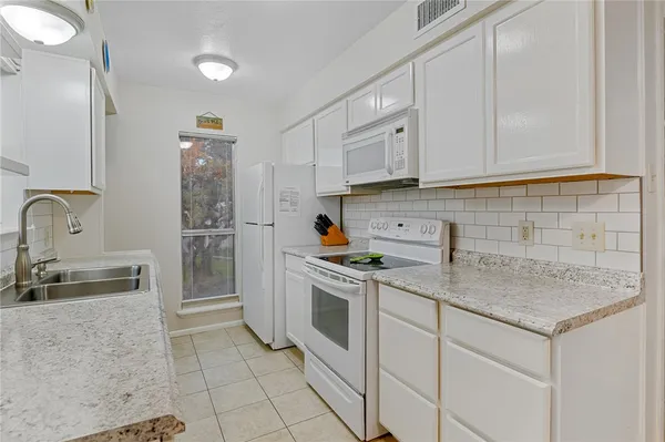a kitchen with stainless steel appliances granite countertop a sink stove and cabinets