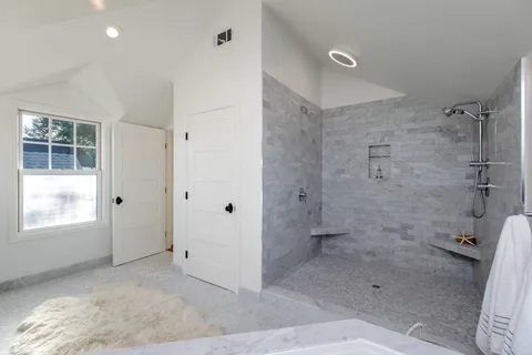 a bedroom with a bed and a lamp on dresser