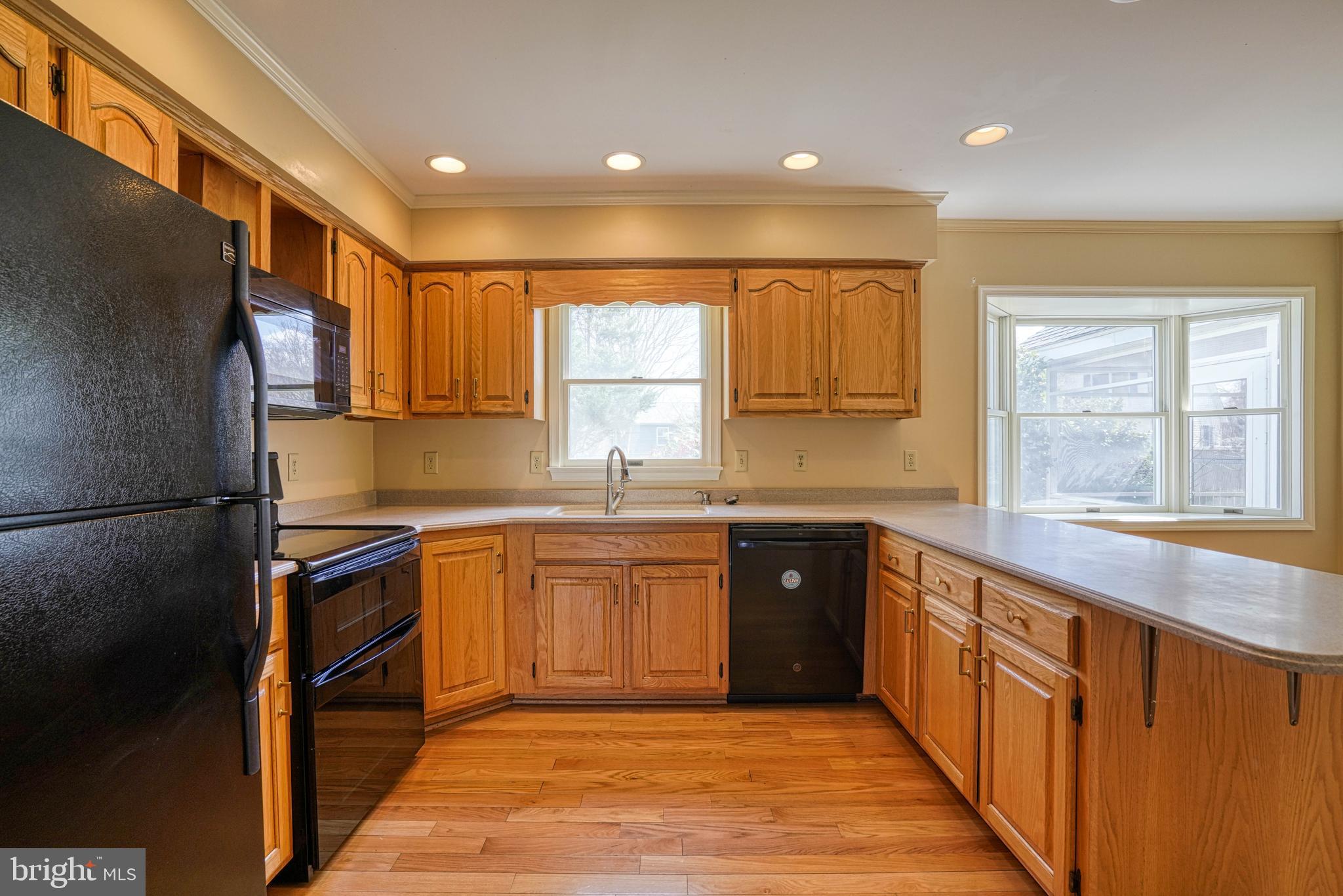200 Spring Drive Easton, MD 21601 - Photo 24 of 54 a kitchen with stainless steel appliances granite countertop a refrigerator a sink dishwasher a stove top oven and a dining table with wooden floor