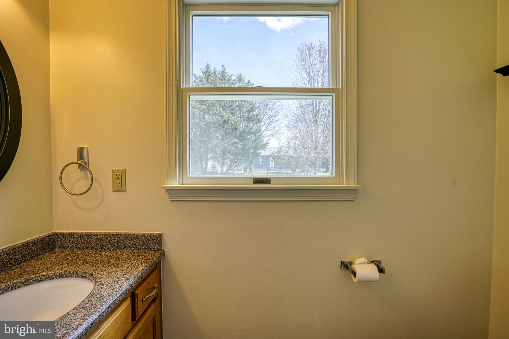 200 Spring Drive Easton, MD 21601 - Photo 26 of 54 a bathroom with a granite countertop sink and a mirror