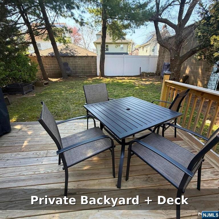 10 Fairview Place Bloomfield, NJ 07003 - Photo 20 of 20 a view of a roof deck with table and chairs with wooden floor and fence