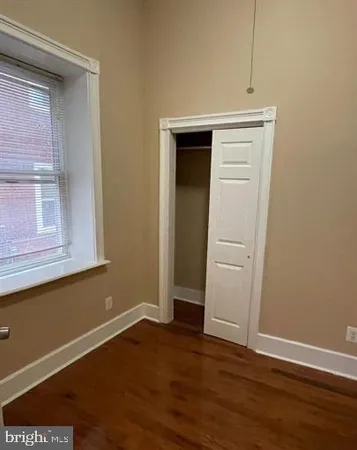 an empty room with wooden floor & closet