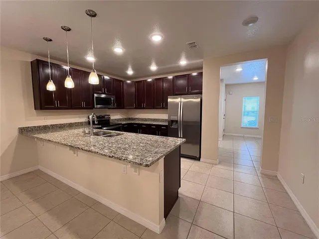 a kitchen with stainless steel appliances granite countertop a sink and a refrigerator