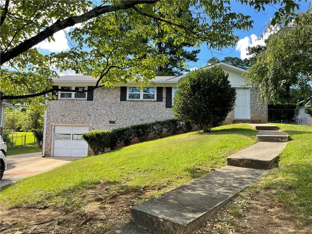 a front view of a house with yard and green space