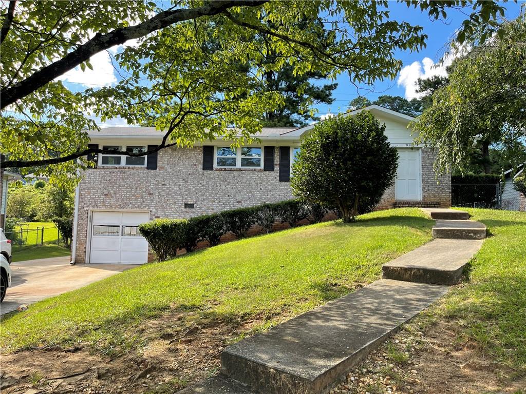 a front view of a house with yard and green space