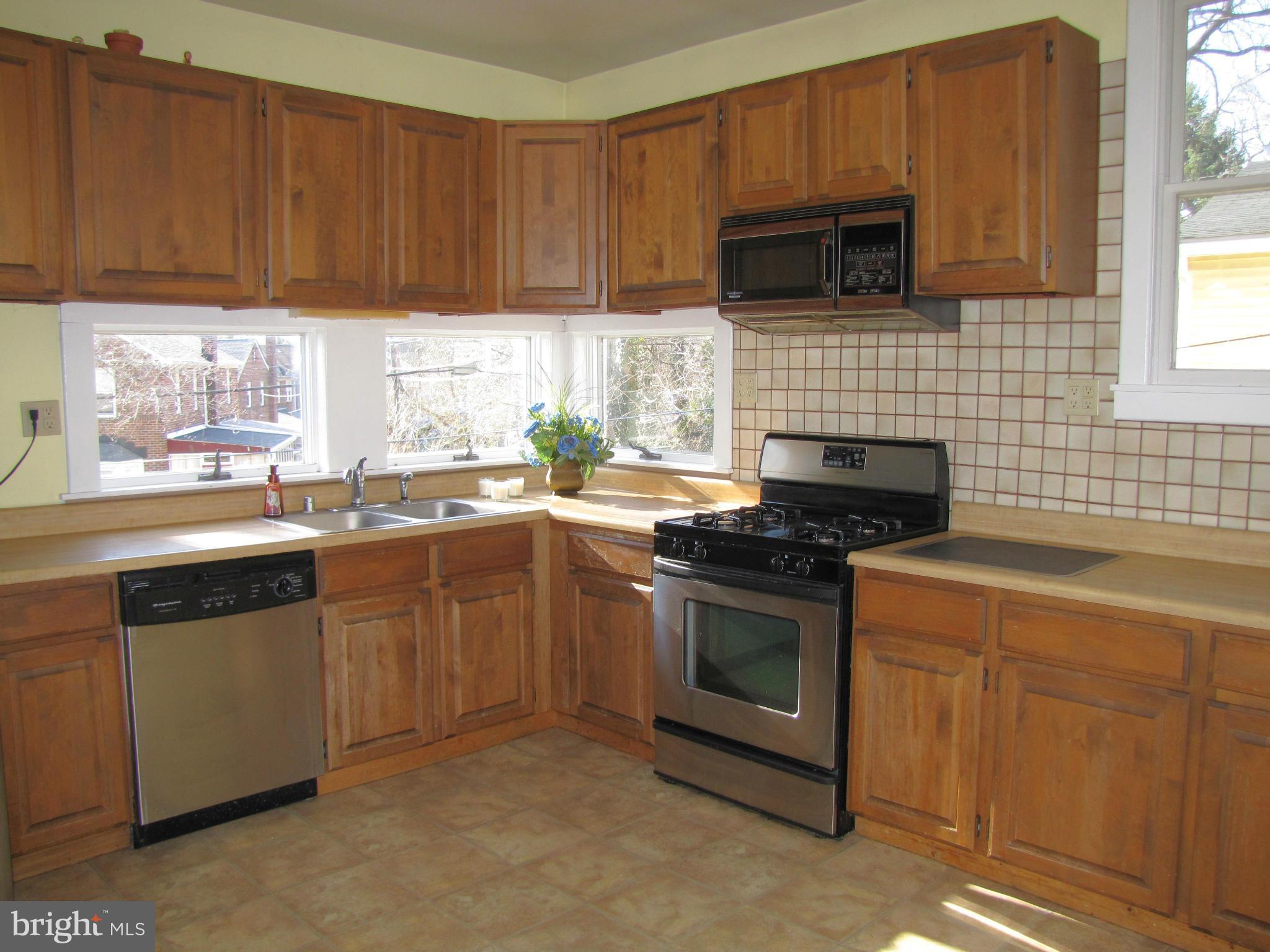 41 Edmondson Ridge Road Baltimore, MD 21228 - Photo 10 of 30 a kitchen with granite countertop a stove top oven microwave and cabinets