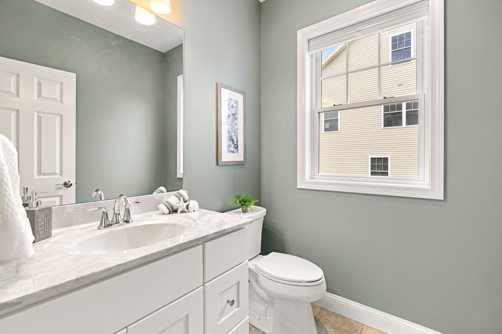 10 Schoolhouse Road, Unit 10 Londonderry, NH 03053 - Photo 15 of 38 a bathroom with a sink a toilet and a window