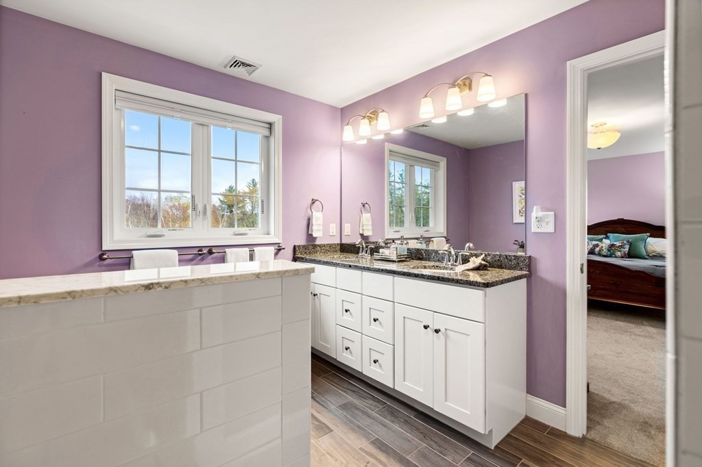 10 Schoolhouse Road, Unit 10 Londonderry, NH 03053 - Photo 21 of 38 a bathroom with a sink vanity and mirror