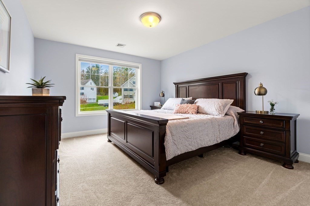 10 Schoolhouse Road, Unit 10 Londonderry, NH 03053 - Photo 22 of 38 a bedroom with a bed and a window