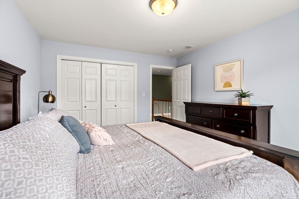 10 Schoolhouse Road, Unit 10 Londonderry, NH 03053 - Photo 23 of 38 a bedroom with a bed and a dresser