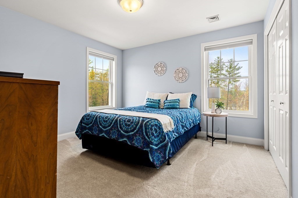 10 Schoolhouse Road, Unit 10 Londonderry, NH 03053 - Photo 24 of 38 a bedroom with a bed and window